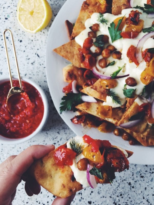 These tasty naan nachos are smothered in a creamy feta cheese sauce with roasted tomatoes, chick peas and fresh herbs!