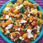 Turmeric Roasted Cauliflower with Honey Harissa Butternut Squash + Crispy Chickpeas with Fresh Herbs + Feta on a blue plate with purple background