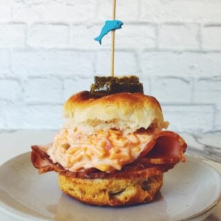 one pimento cheese biscuit slider on a white plate with a white background