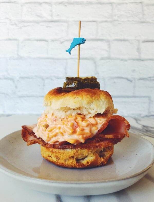 one pimento cheese biscuit slider on a white plate with a white background