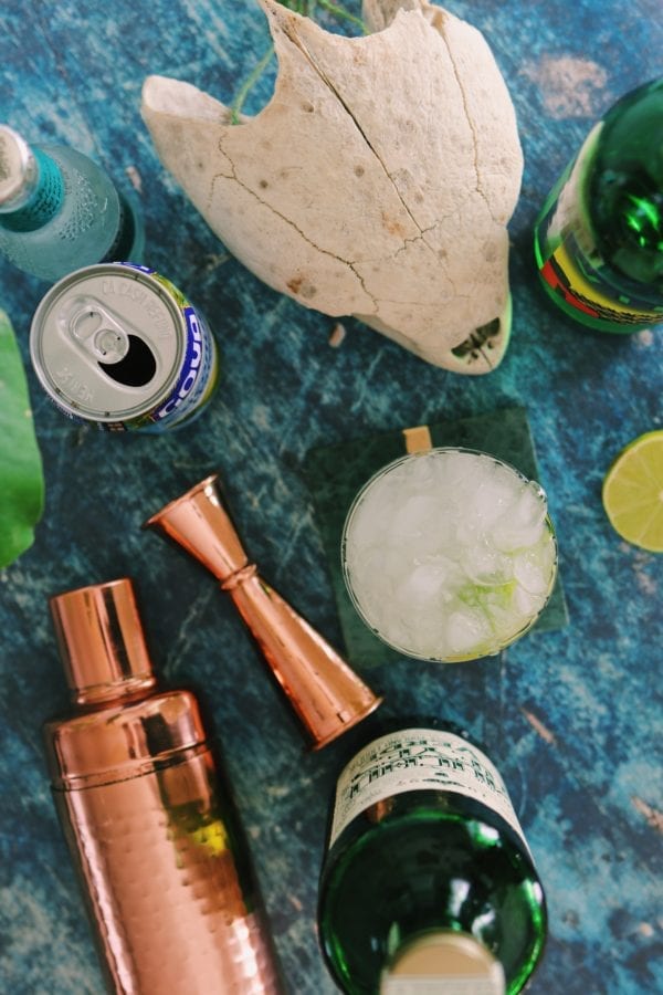 overhead shot of margarita ingredients with bronze shakers