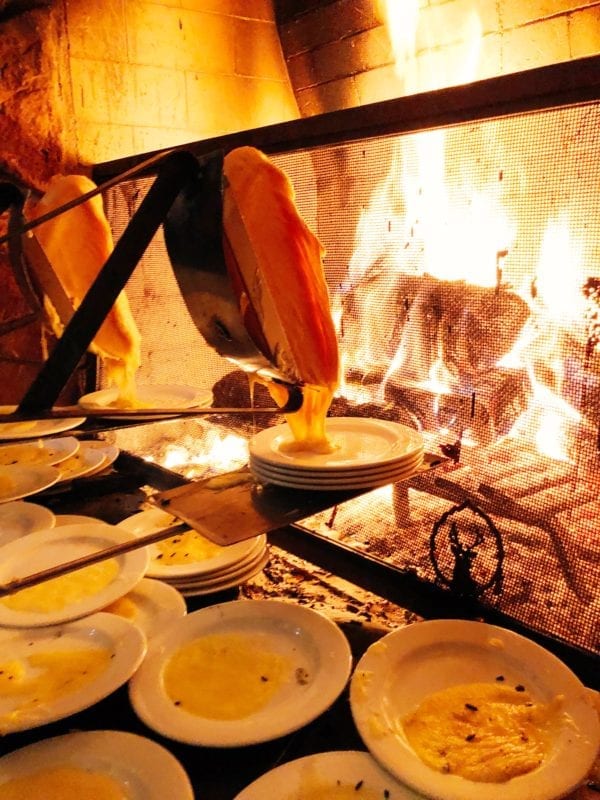 Hot melty raclette cheese melting over a fireplace at Fireside Dining, Deer Valley Utah