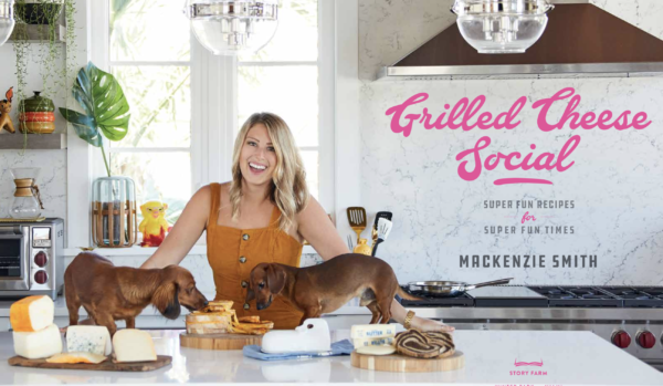 mackenzie smith of grilled cheese social with her two dachshunds in a kitchen