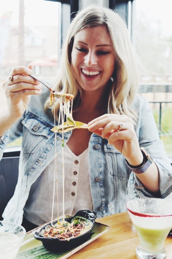 MacKenzie Smith doing a cheese stretch with queso fundito and a bright green avocado margarita