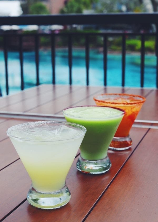 three different colored margaritas in front of disney's springs