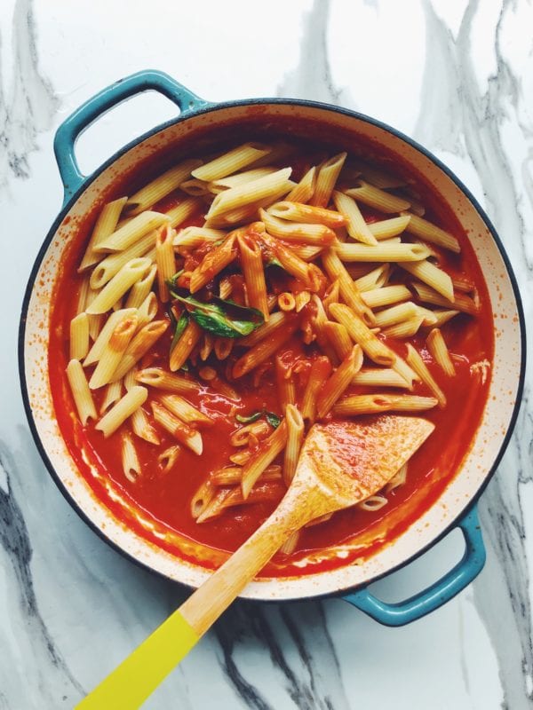 a pot of penne pomodoro with wilted basil on top