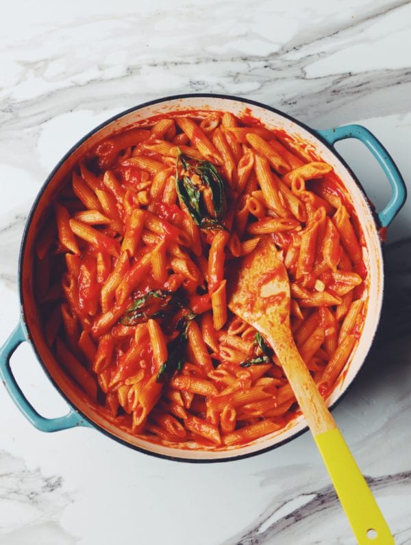 a pot of penne pomodoro with wilted basil on top