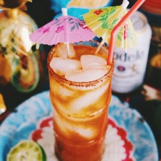 a red michelada on a brightly colored table