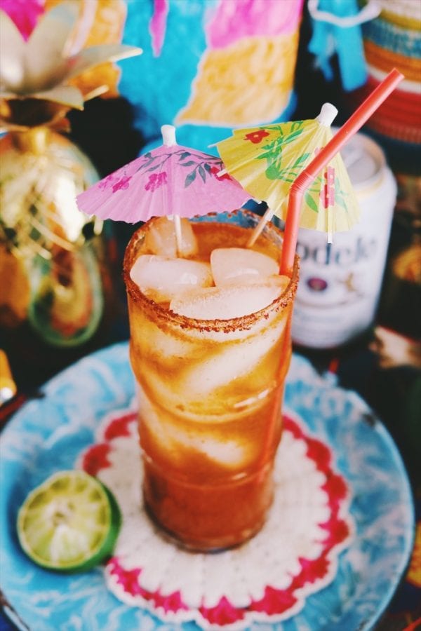a red michelada on a brightly colored table