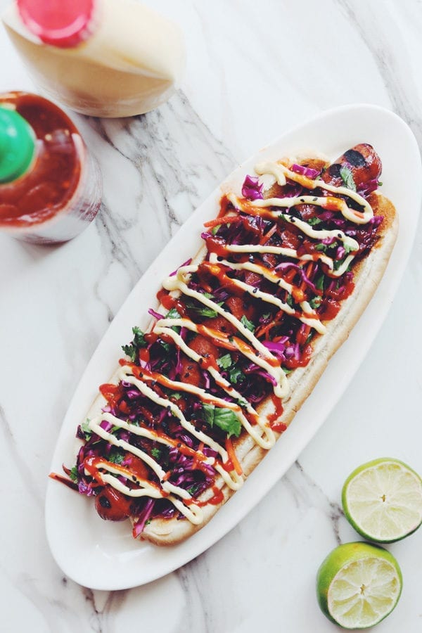 asian slaw foot long hot dog on a table with lime