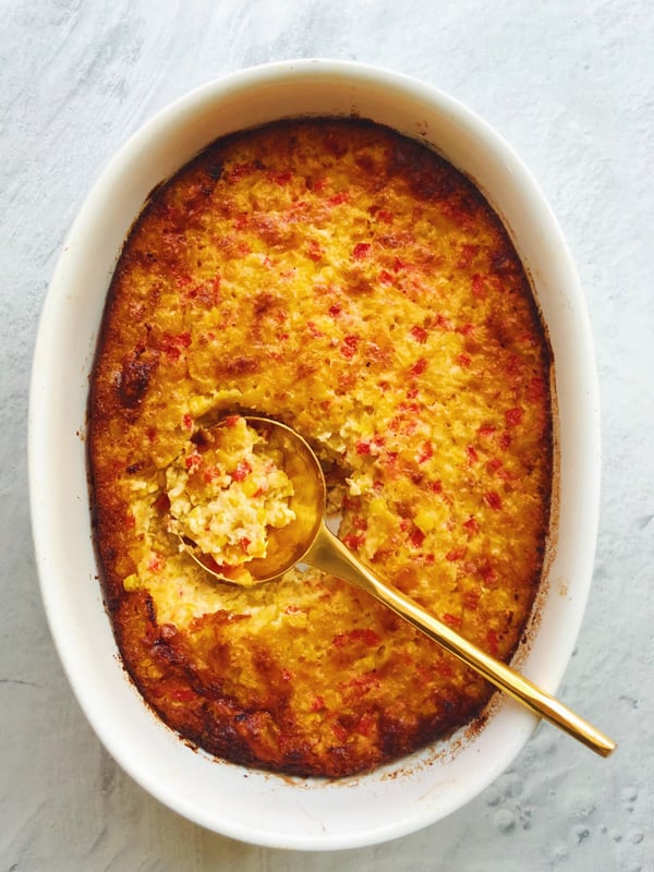 Grandmas Corn Pudding with a golden spoon.