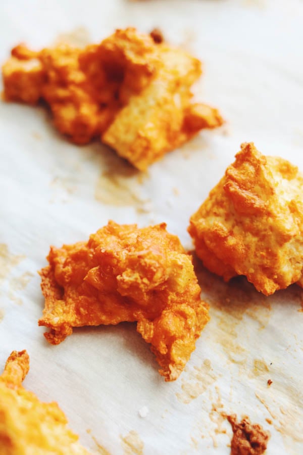 These crispy baked buffalo tofu wings are super easy to make and they taste SO GOOD! They're made by tearing pressed tofu into nuggets and tossing them in a slurry of buffalo sauce, parmesan cheese and cornstarch. After baking, they turn into crunchy, spicy and savory tofu buffalo wings! I  like to serve them loaded with blue cheese, ranch and scallions but you could totally eat them plain, too! 
