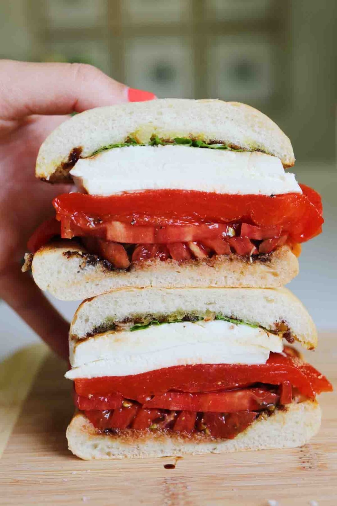 a stacked caprese sandwich that's cut in a half.