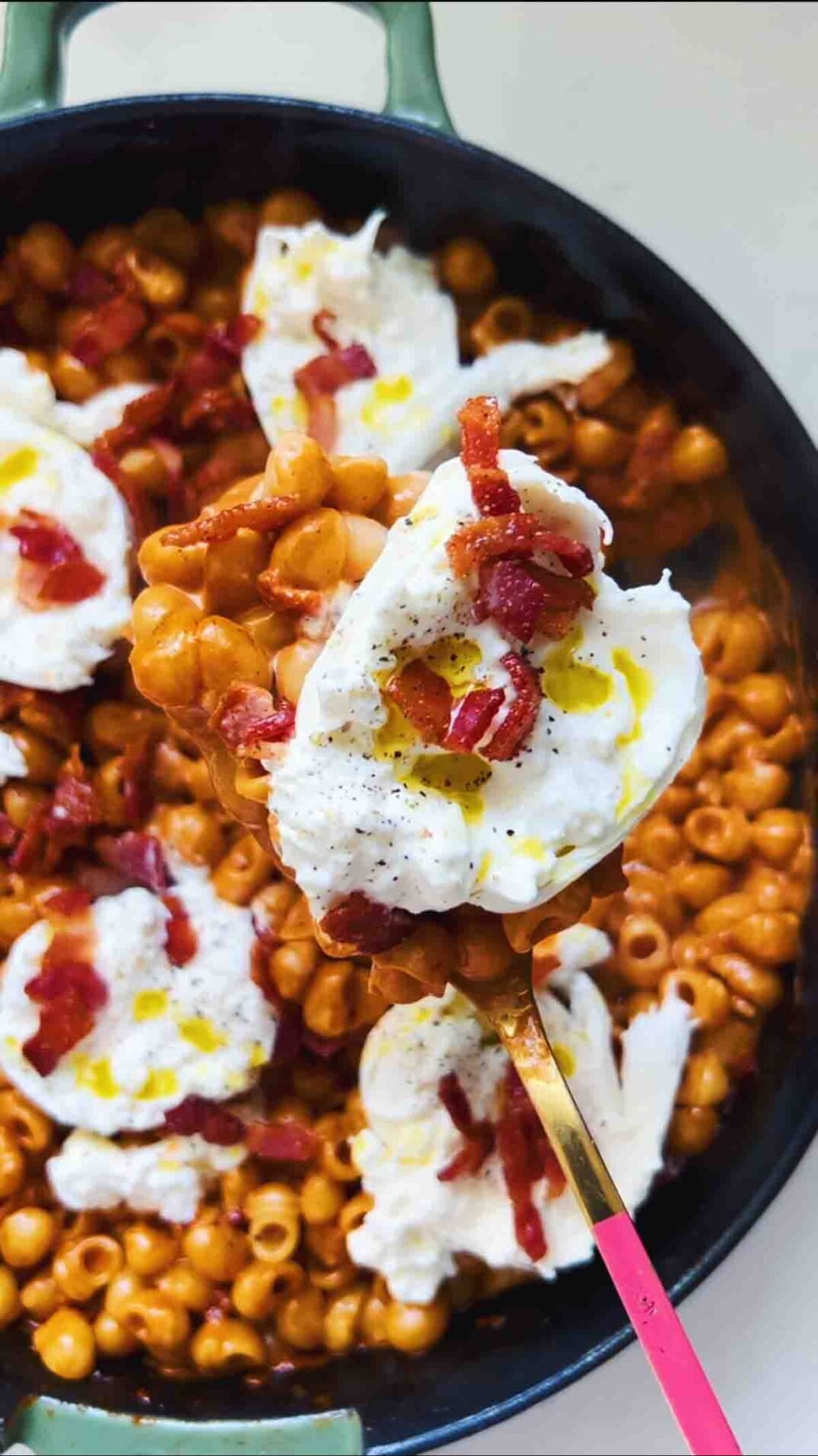 burrata and bacon on top of a skillet full of spicy vodka pasta.