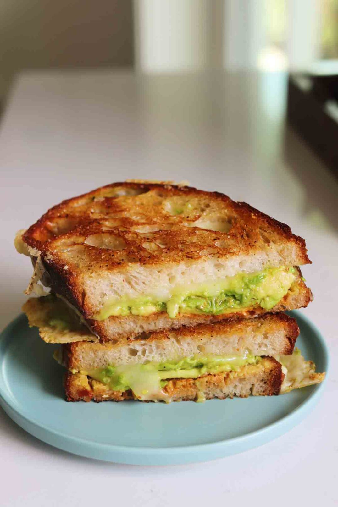 chipotle avocado grilled cheese on a blue plate.