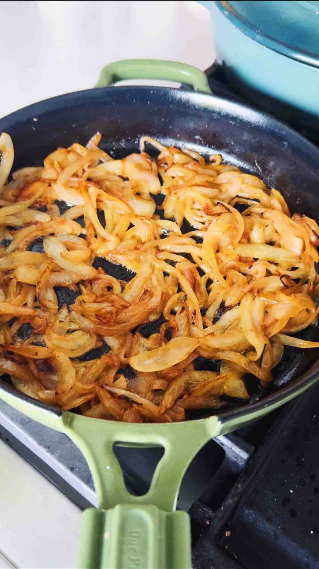 caramelized onions in a green fry pan.