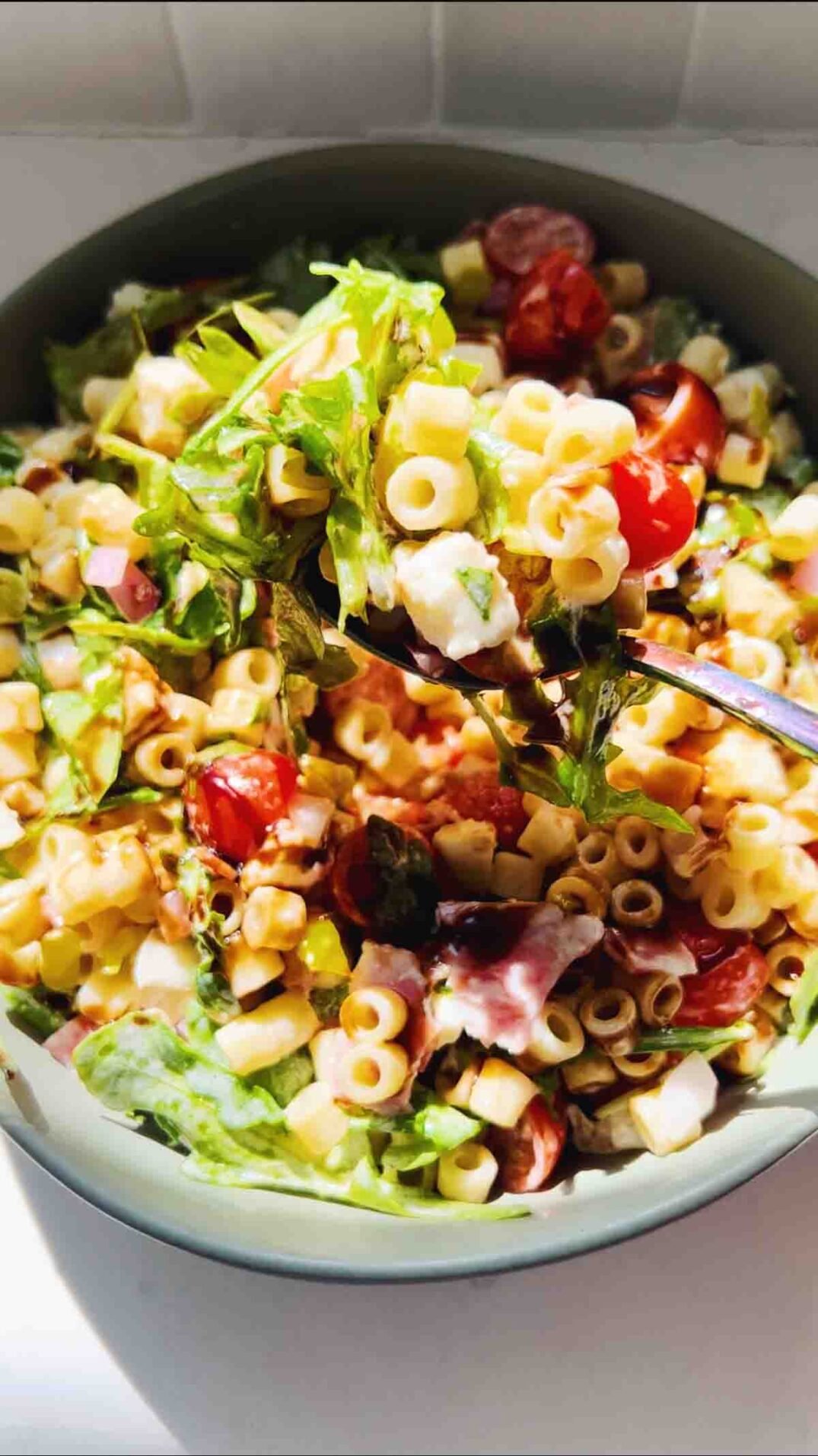 a close up of a fork full of viral grinder pasta salad.