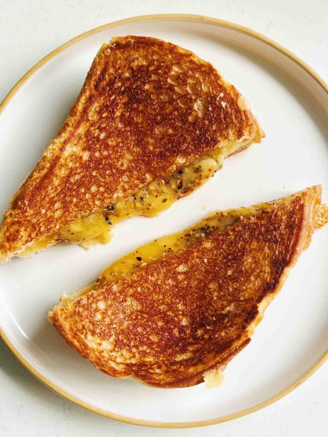 golden grilled cheese on a white plate.