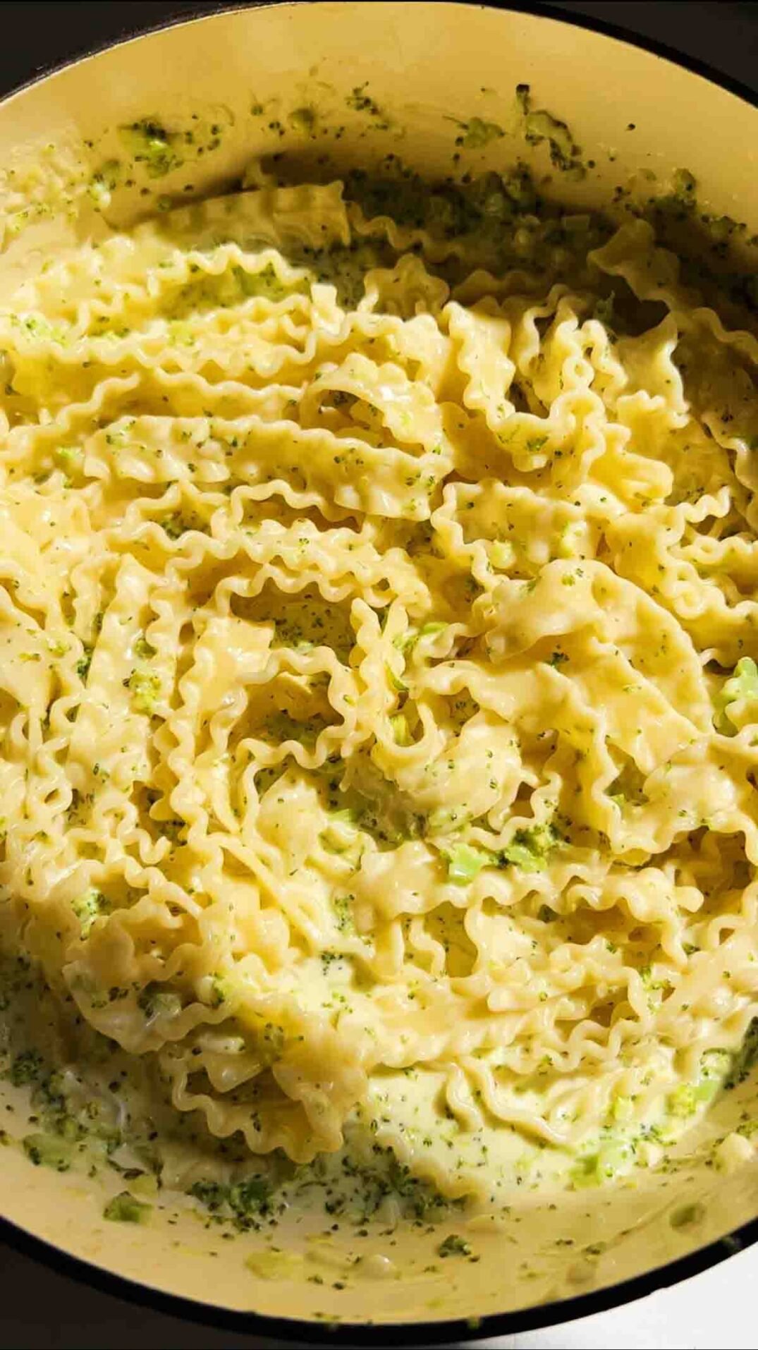 an overhead view of mafaldine pasta limone with broccoli.