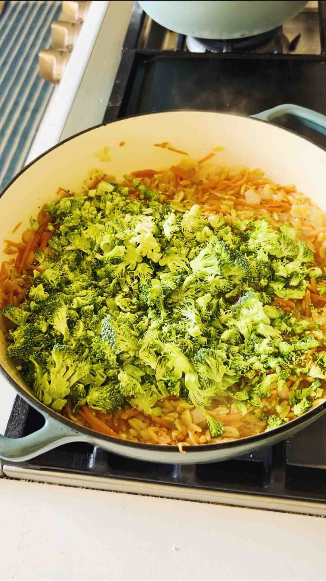 fresh broccoli in a blue braising dish.