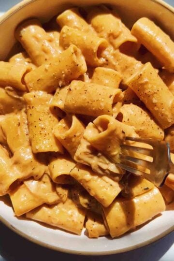 a fork going into a bowl of the viral french onion pasta.