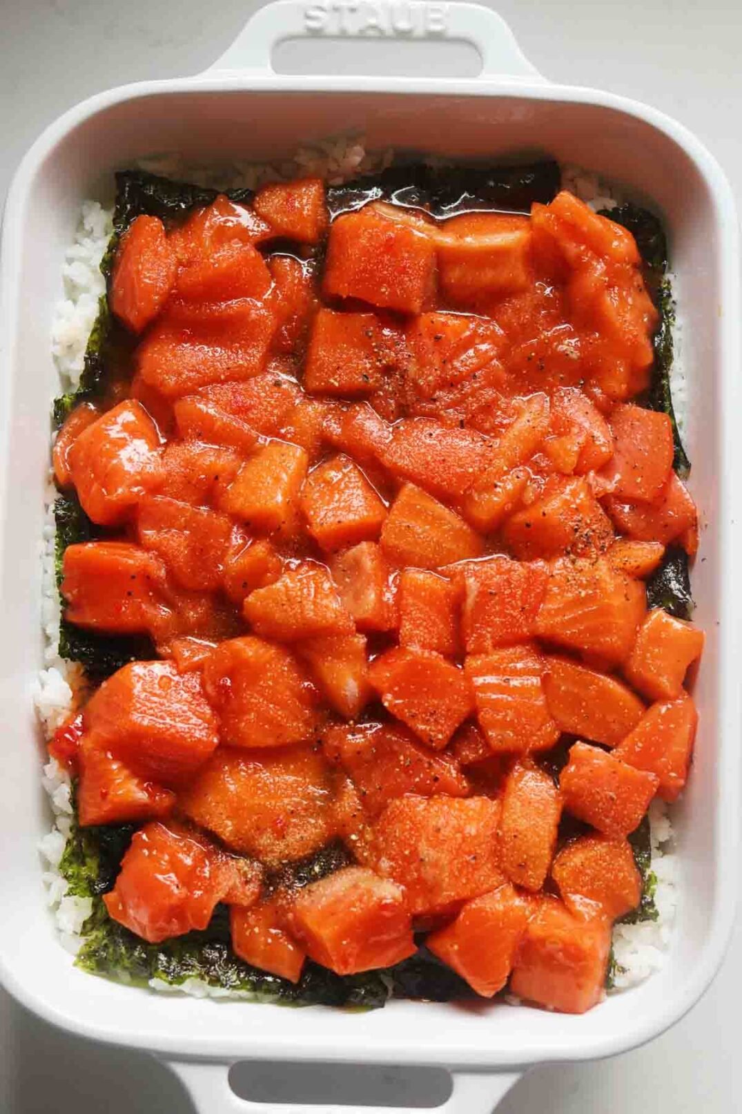 sweet chili glazed salmon in a white baking dish.