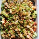 an entire shot of a fully loaded salmon sushi bake in a white baking dish on a white countertop.