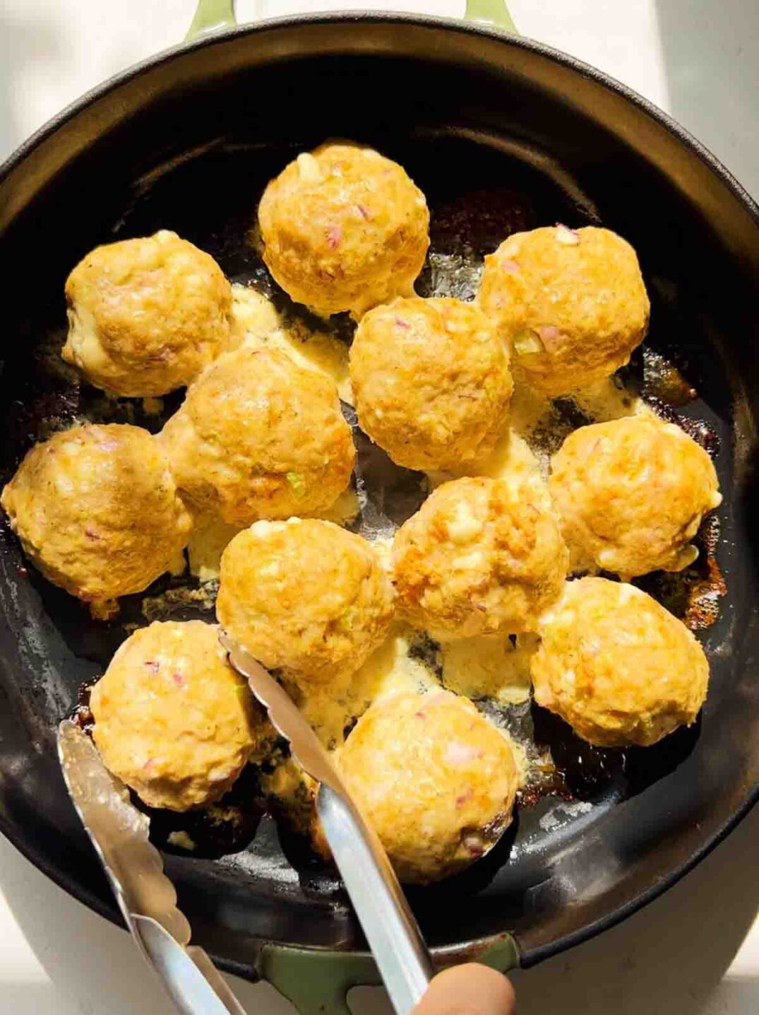 cooked chicken meatballs in a cast iron skillet.
