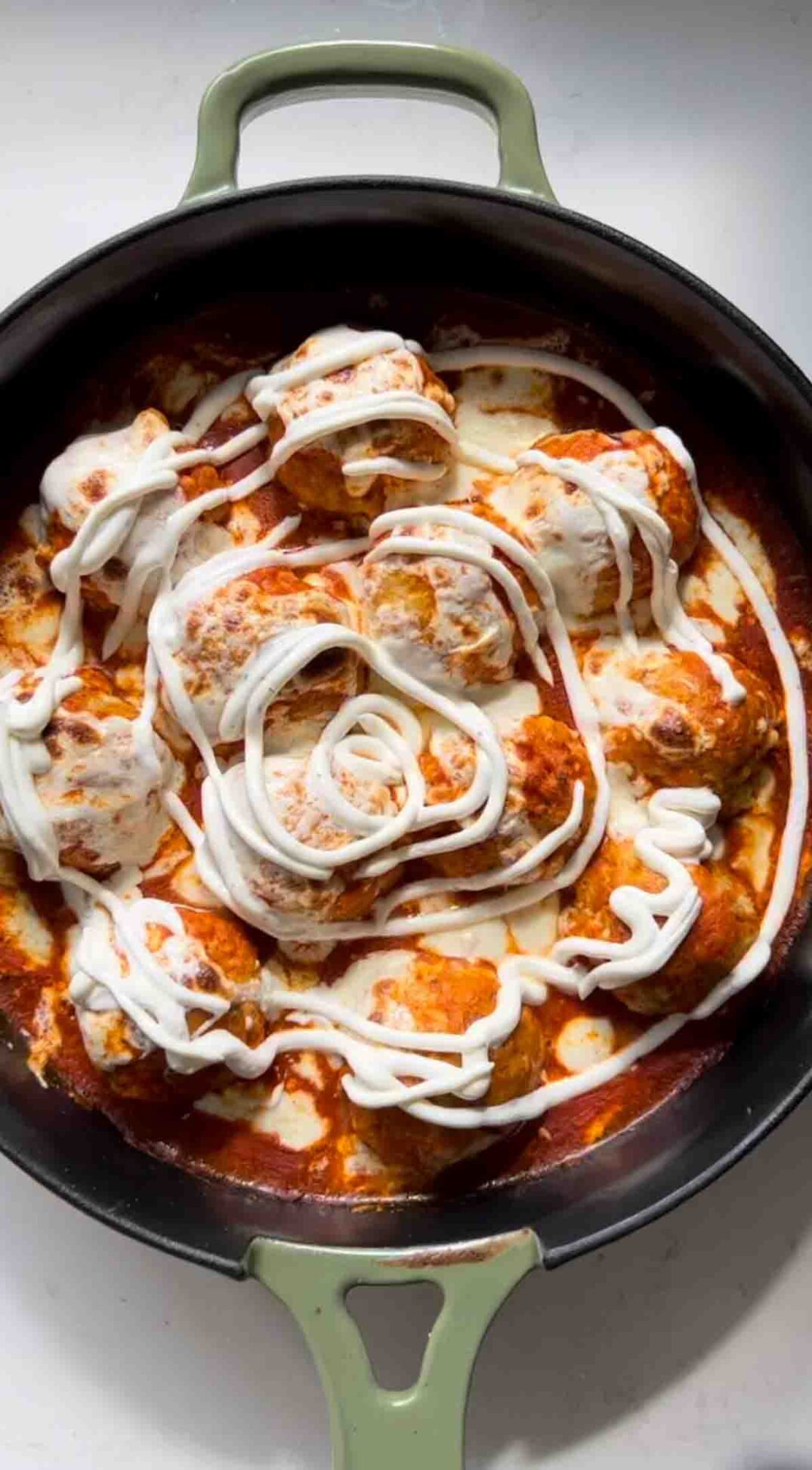 a swirl of ranch dressing on top of buffalo chicken meatballs