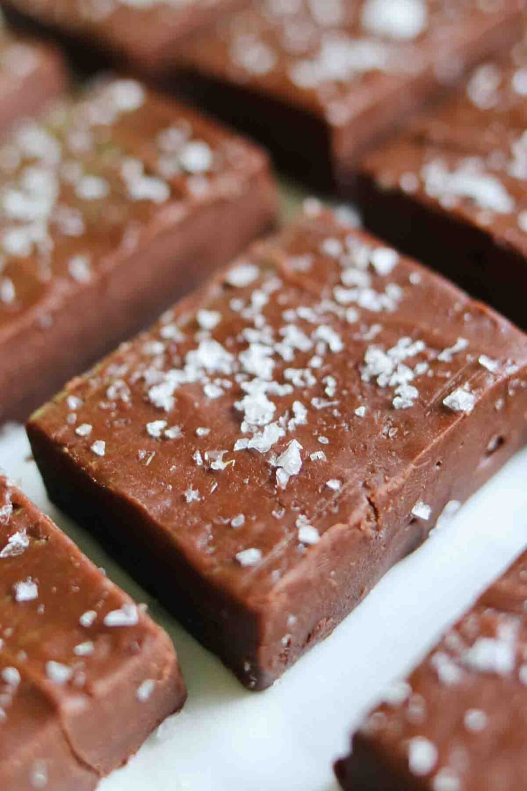 a square of nutella fudge sprinkled with flaky salt on a white surface.