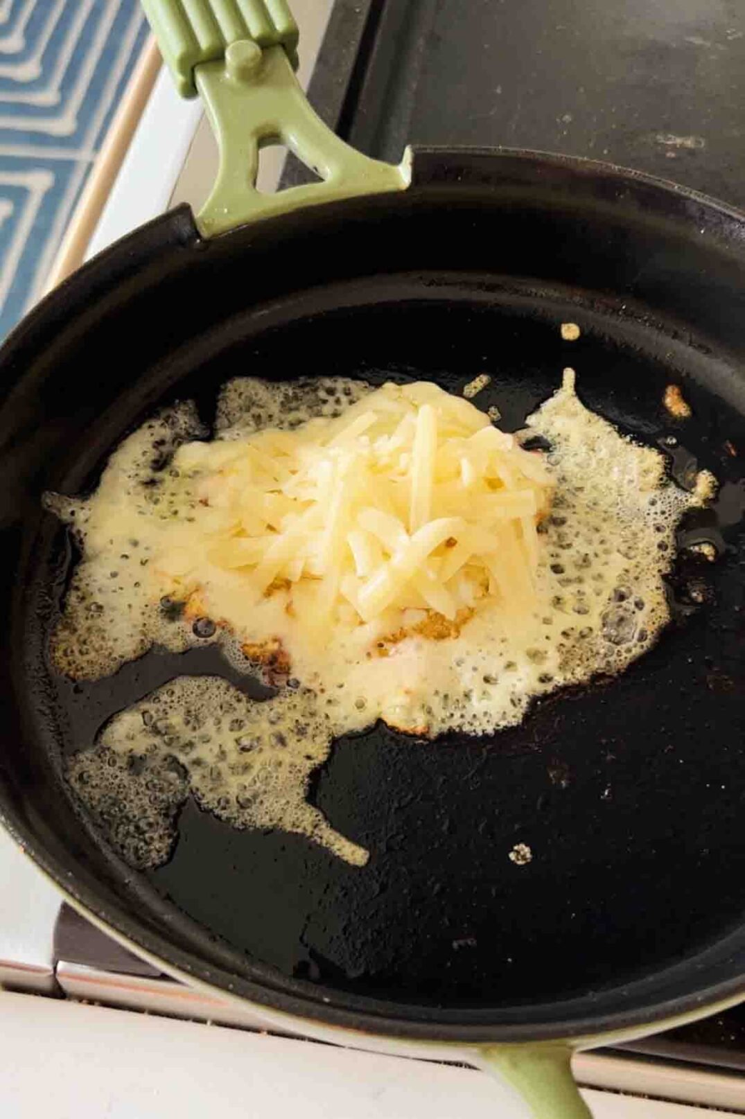 melted gruyere cheese on a fried egg in a black cast iron.