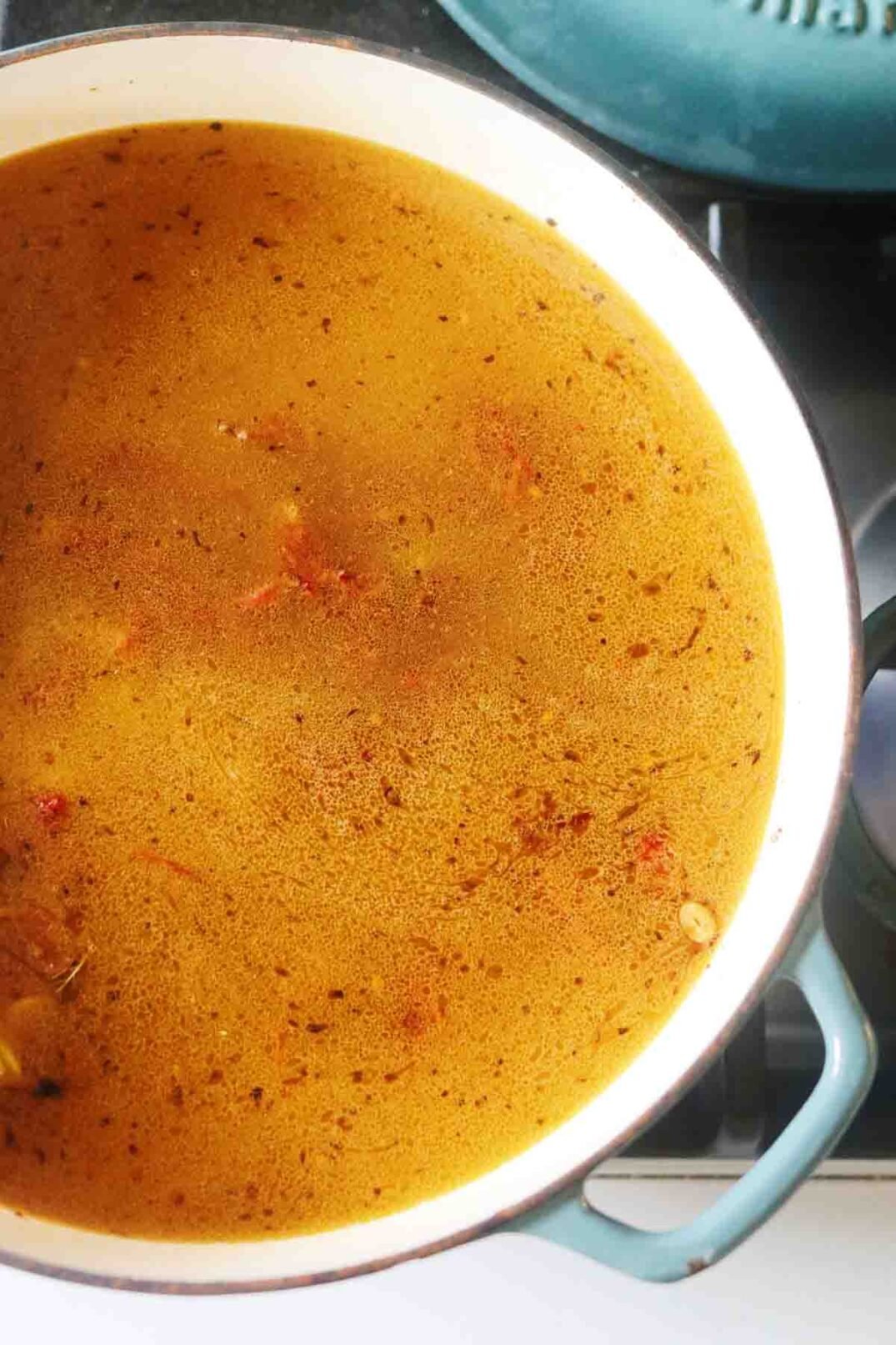 golden broth in a blue pan on the stovetop.