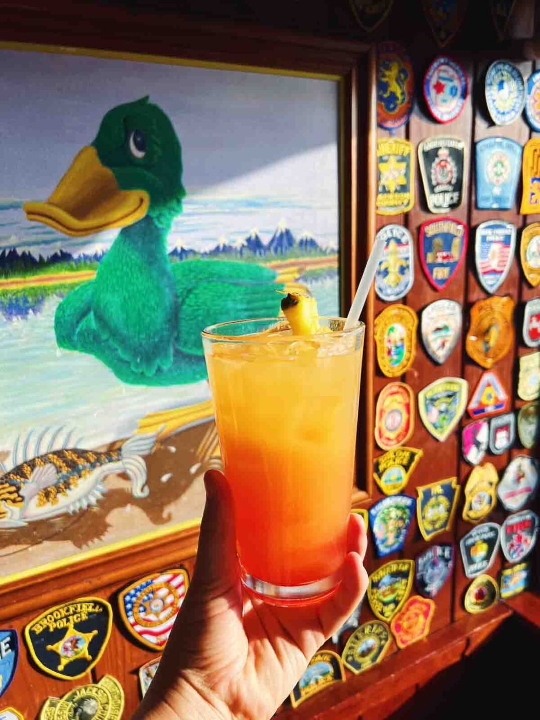 a colorful orange and red cocktail in front of the mucky duck painting in captiva island. 