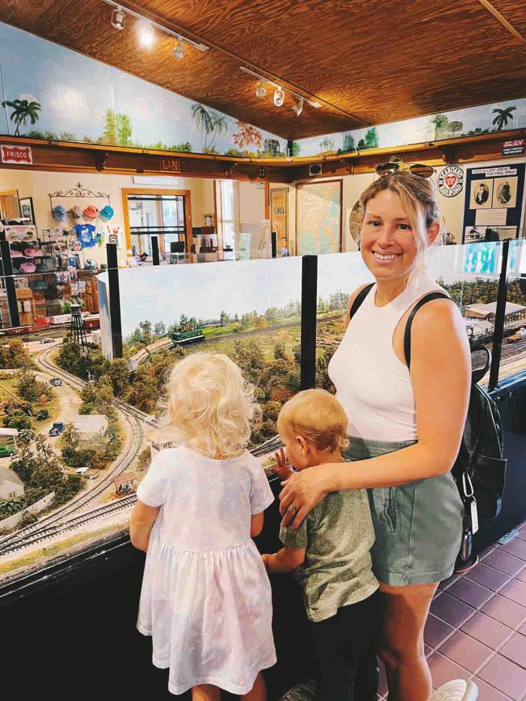 a family looking at the model train area at lakes park
