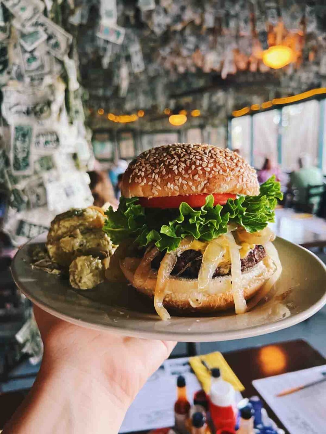 a hand holding jimmy buffett 's famous cheeseburger in paradise on captiva island. 