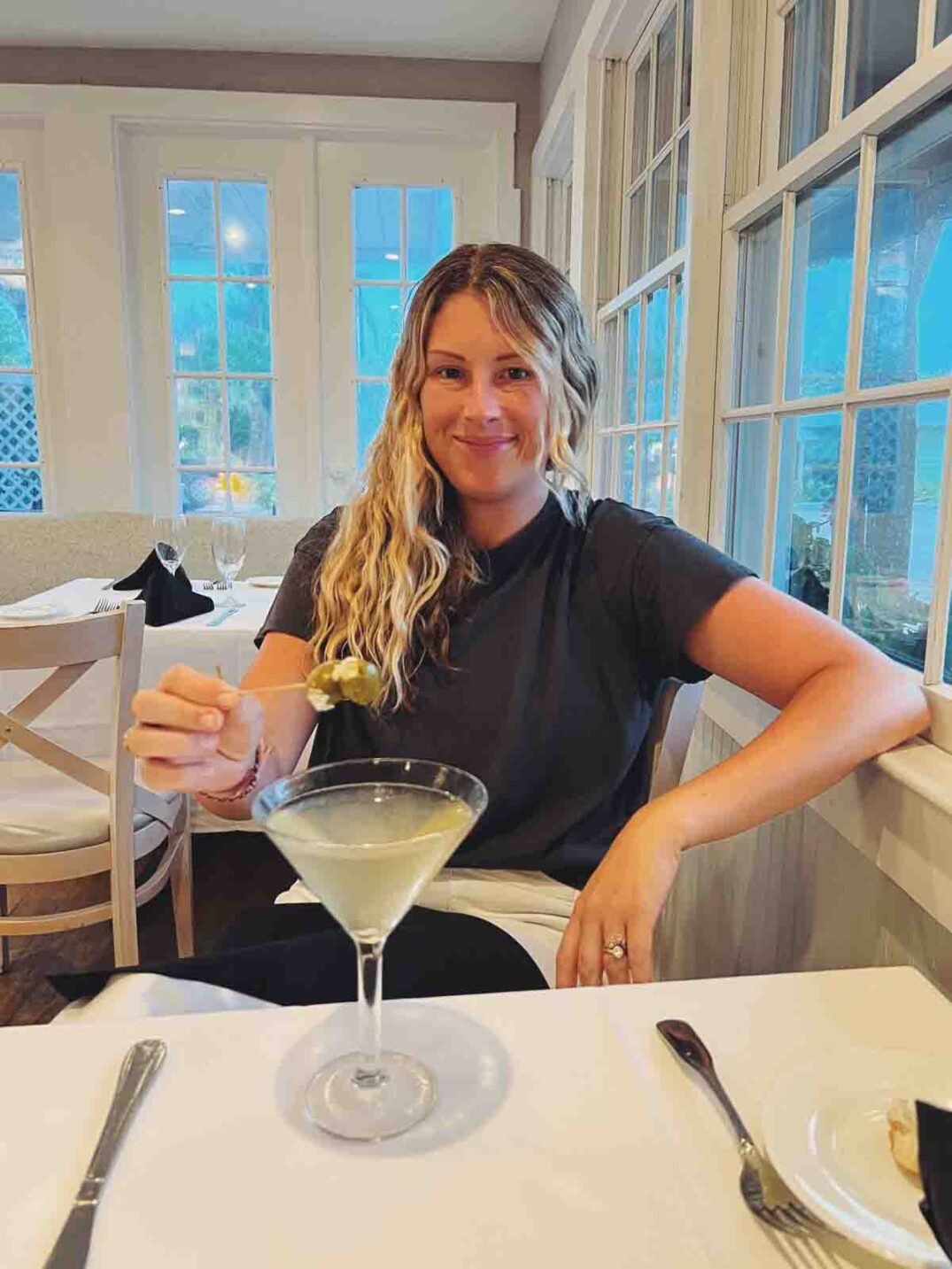 mackenzie smith holding a dirty martini at tween waters in captiva island