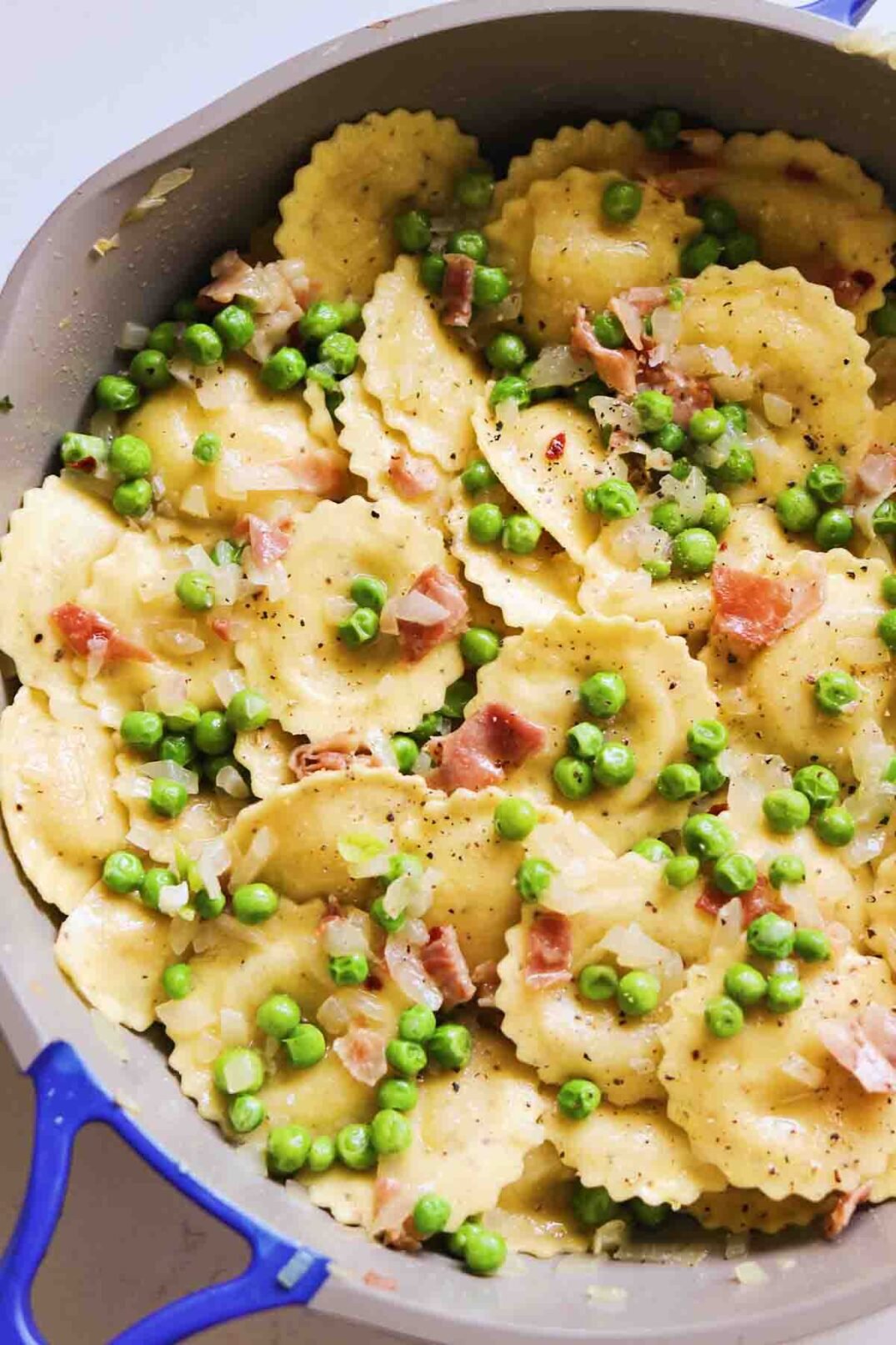 Trader Joe's Cacio e Pepe Ravioli cooked with peas and prosciutto topped with parmigiano and fresh cracked pepper.