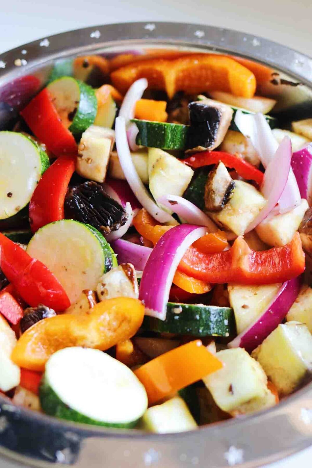 chopped colorful veggies in a big silver bowl.