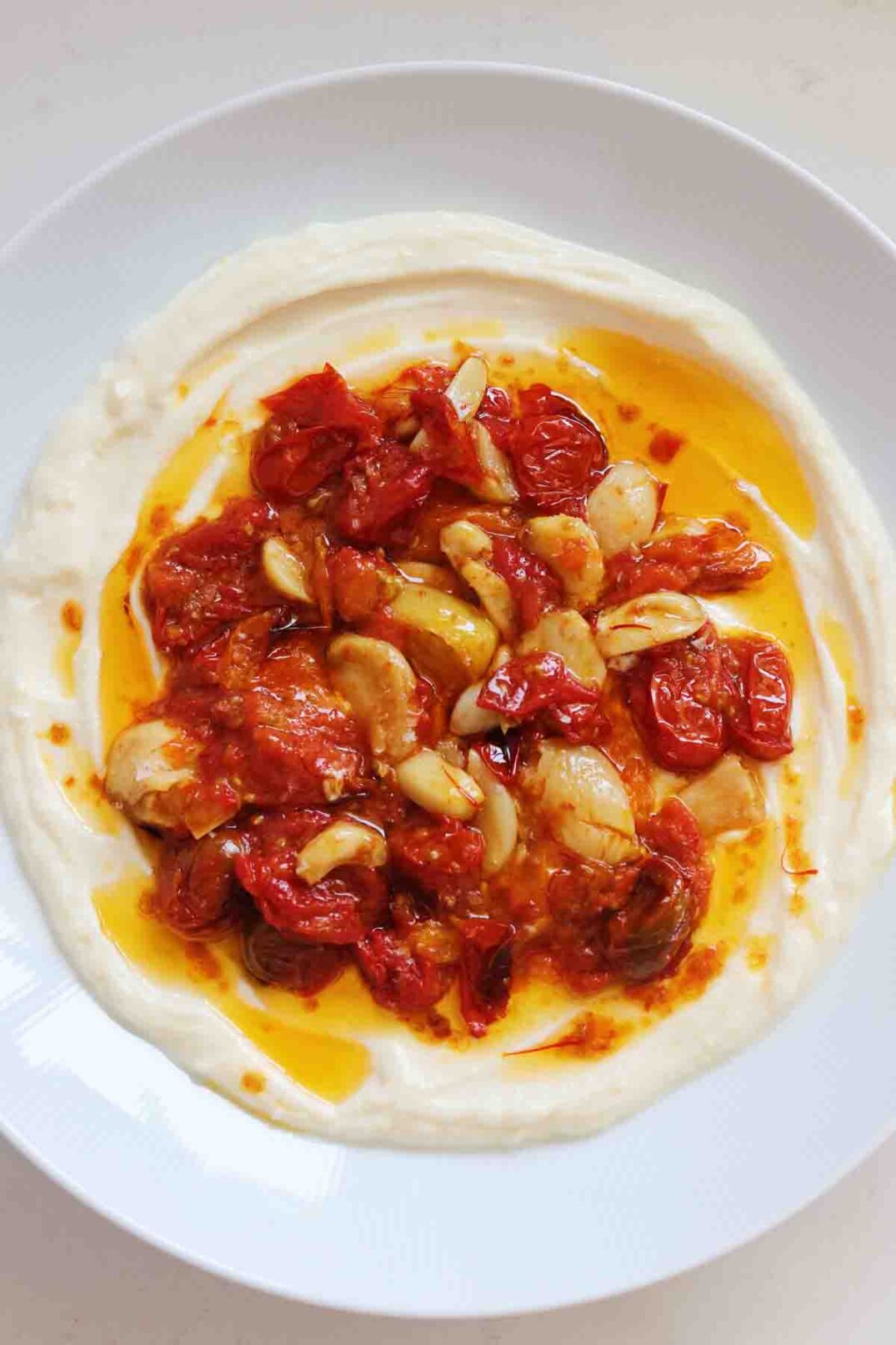 an overhead view of a bowl of tomato confit and whipped ricotta.