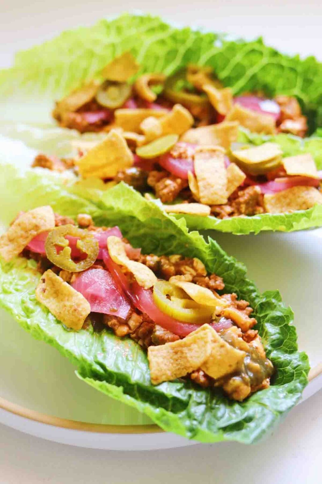 3 cottage cheese taco meat wraps with pink pickled onions, jalapenos and fritos.