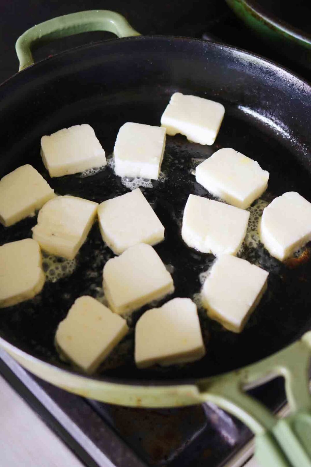 fresh chopped halloumi in a fry pan.