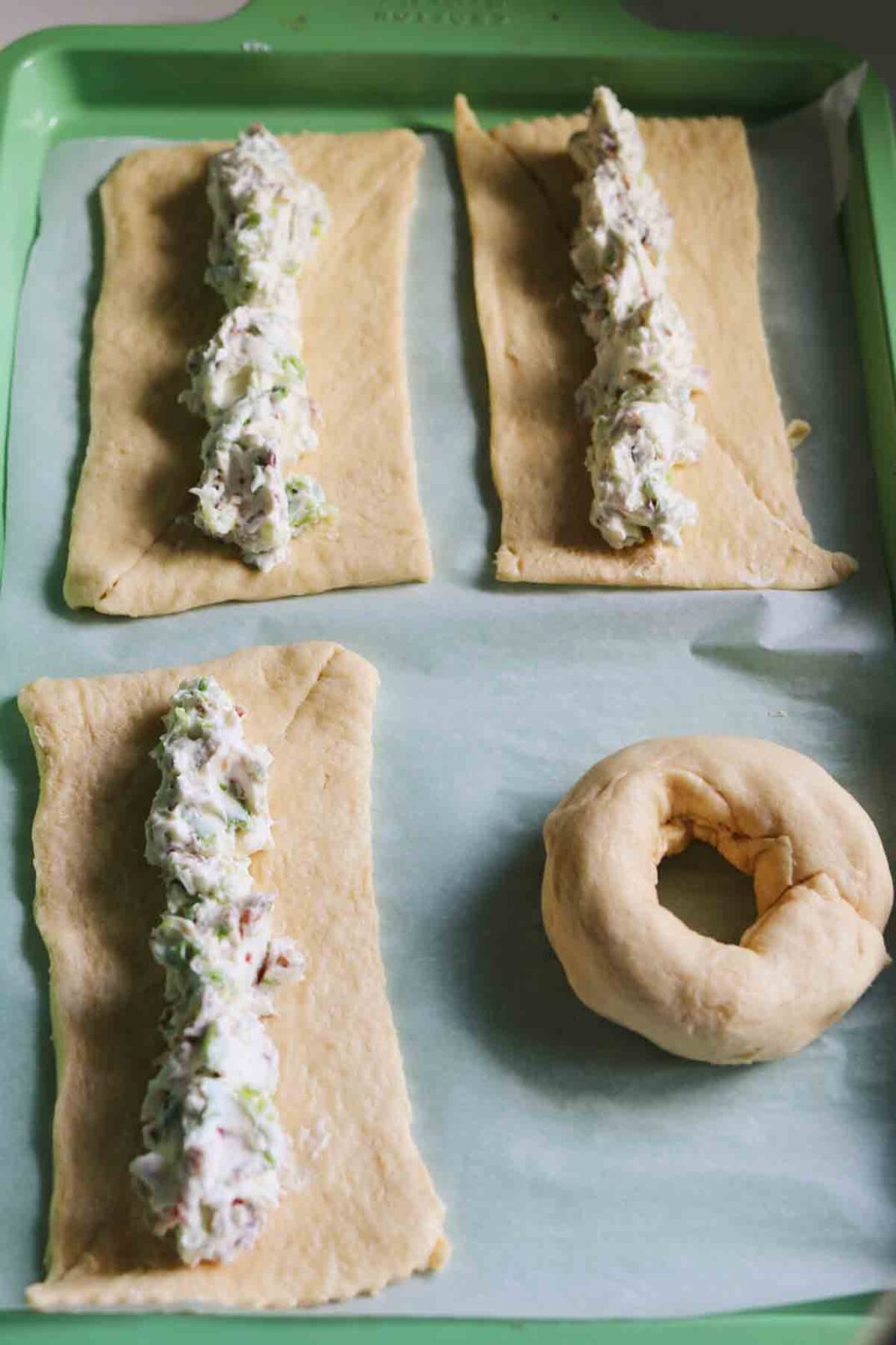 bacon scallion cream cheese getting wrapped up in a stuffed bagel.