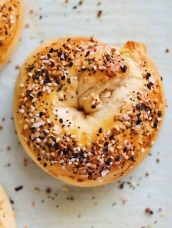 stuffed bagels with everything bagel seed on top of a baking sheet.