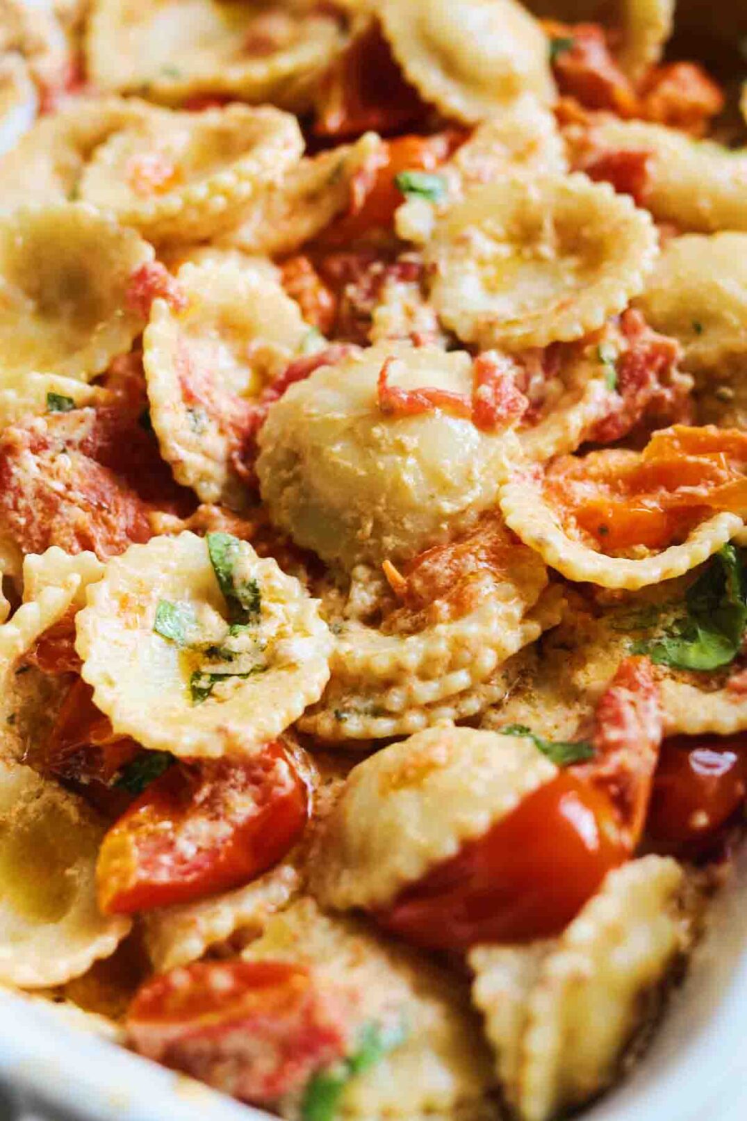 melted tomatoes, creamy boursin and pasta in a white baking dish.
