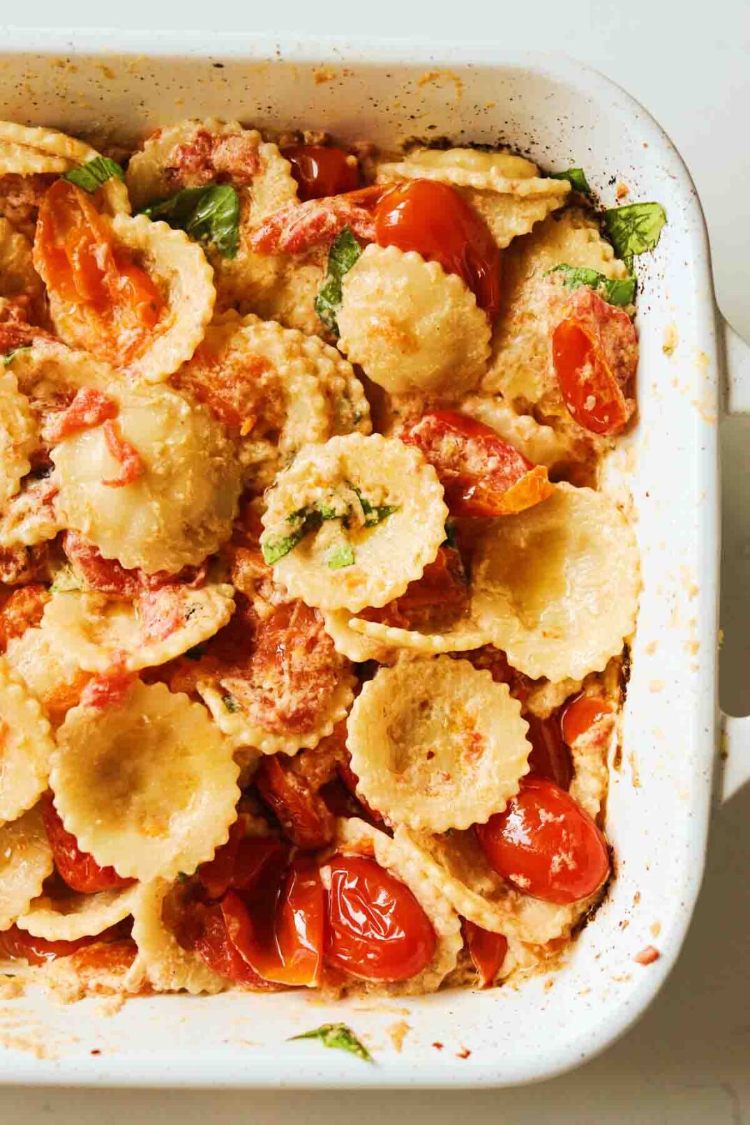the left side of a white staub baking dish filled with Baked Boursin Cheese Pasta Recipe.