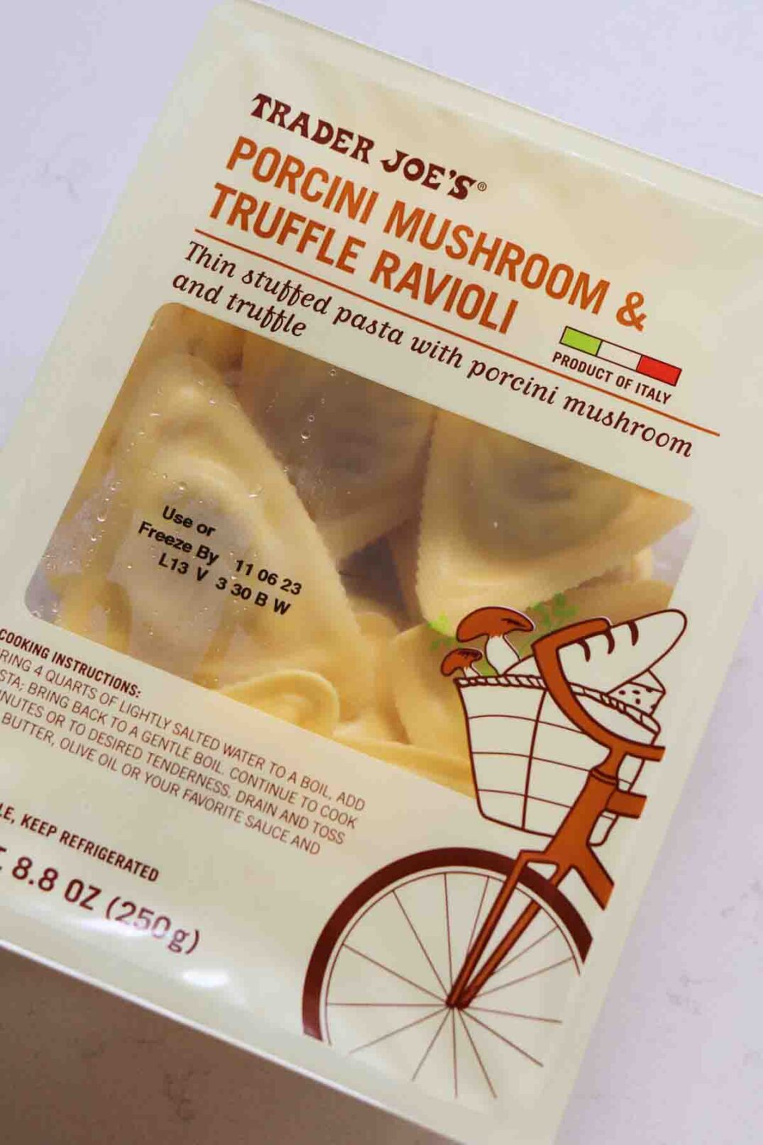 a plastic container of Trader Joe's Porcini Mushroom Ravioli  with Truffle Cream Sauce.