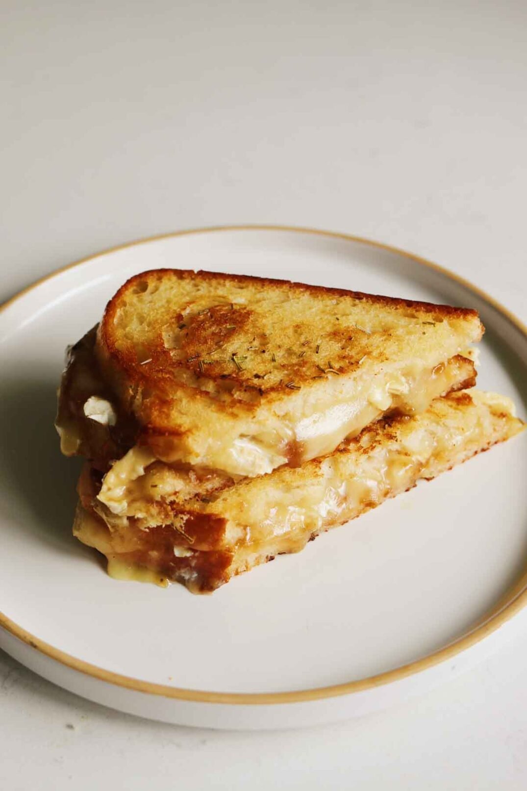 a brie grilled cheese sitting on a white plate. 