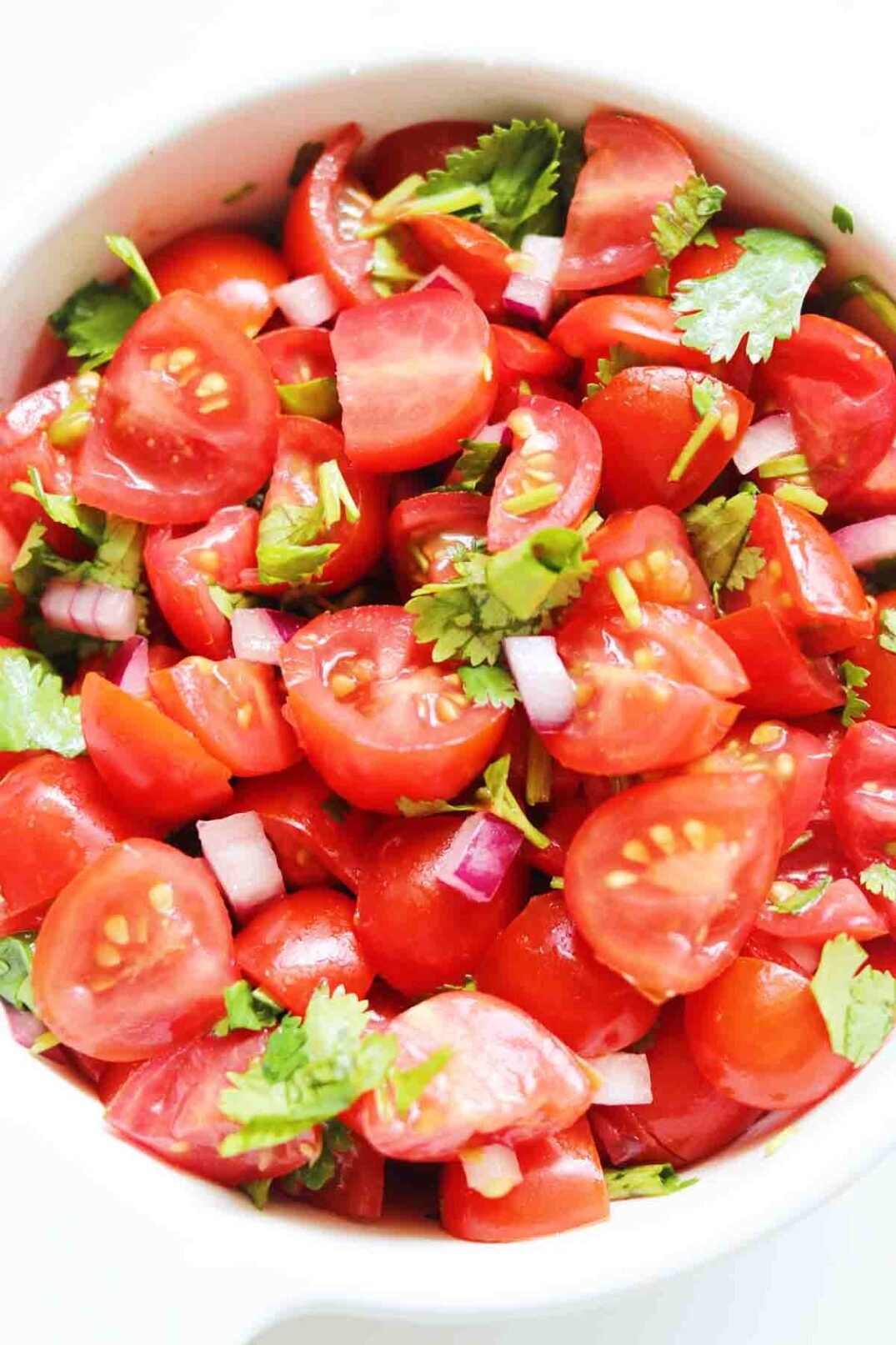 a big white bowl of colorful chopped cherry tomato salsa. 