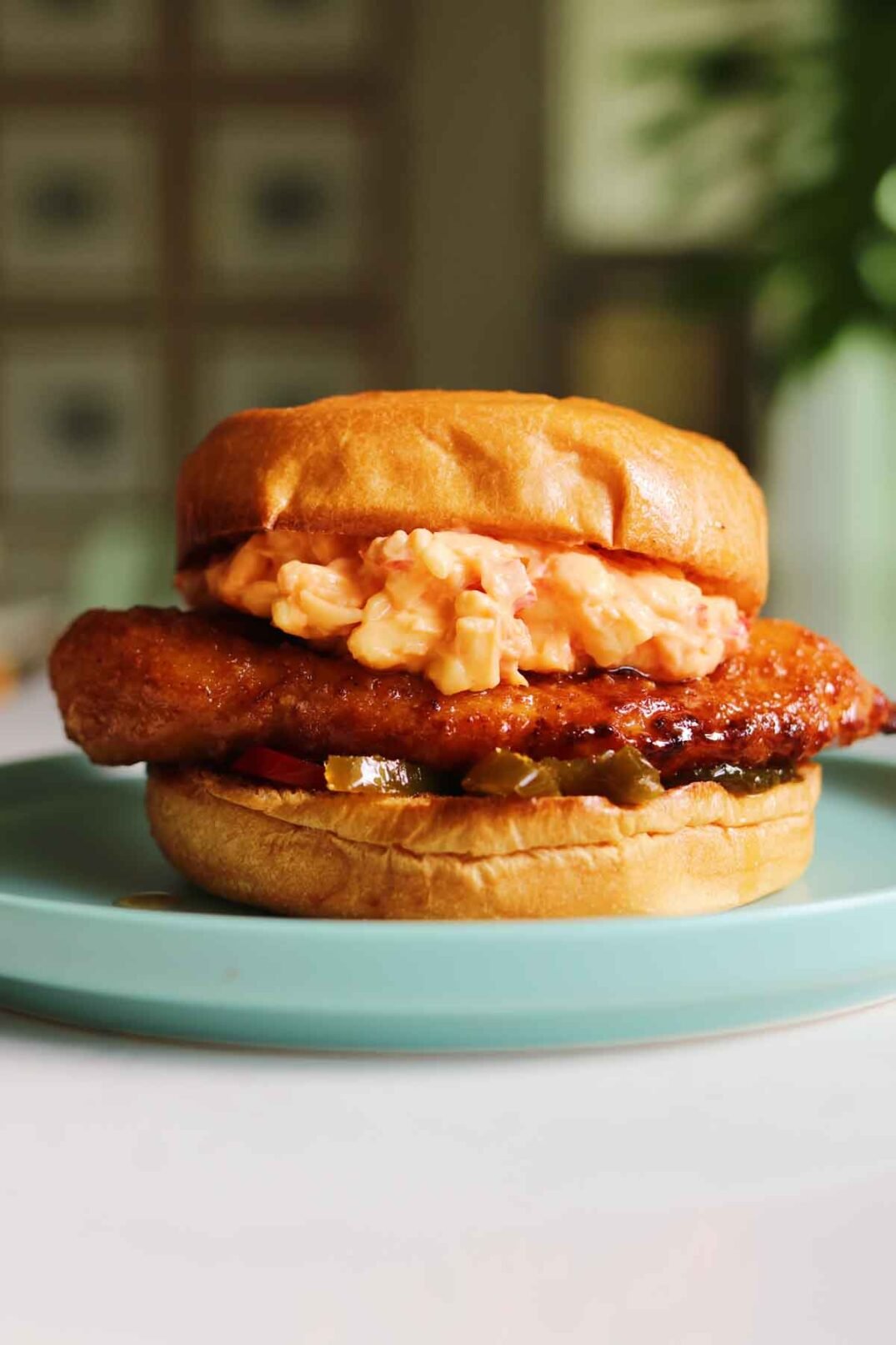 a copycat version of a Chick-fil-a Honey Pepper Pimento Chicken Sandwich sitting on a blue plate. 