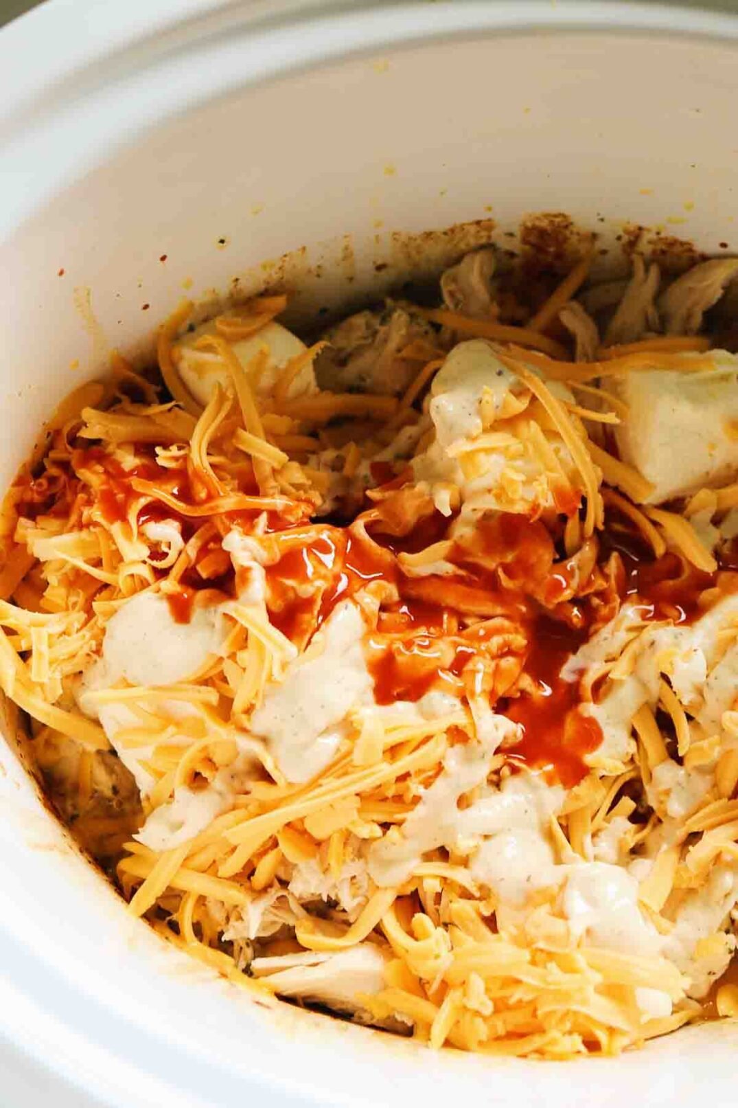 shredded cheeses in a crockpot to make buffalo chicken dip.